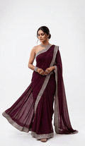 Woman wearing a maroon saree with silver border on a white background